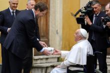 Ola Källenius, CEO of Mercedes-Benz, presents the key for the new all-electric popemobile to Pope Francis during a meeting at the Vatican Dec. 4. (CNS/Lola Gomez)