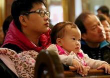 A man holds a child during Mass celebrated in February 2018 at Transfiguration Church in New York City. (CNS/Gregory A. Shemitz)