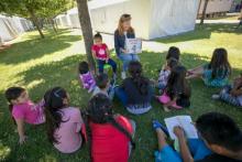 Jean Stamatis, a volunteer from Sts. Faith, Hope and Charity Parish in Winnetka, Illinois, reads to children as part of the Literacy Wagon program for children of migrant families in the Diocese of Yakima, Washington. (Catholic Extension/Rich Kalonick)