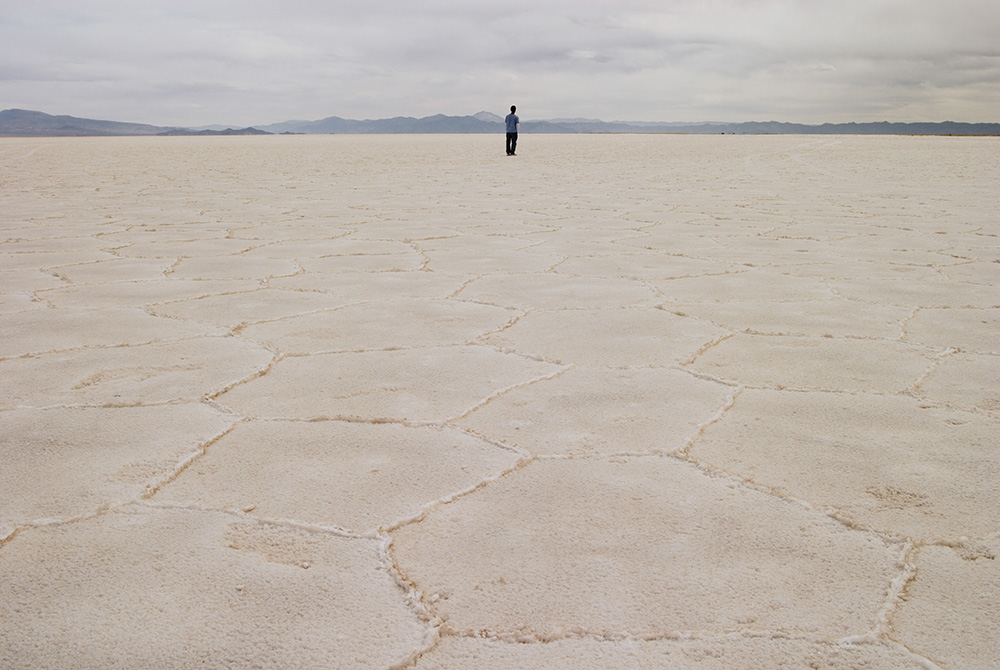 A person stands on the salt flat Salar de Arizaro, in Salta province, Argentina. In Salta and Jujuy provinces, Indigenous communities, whose livelihood depends on the extraction of salt from great deposits, oppose lithium mining, which directly impacts th