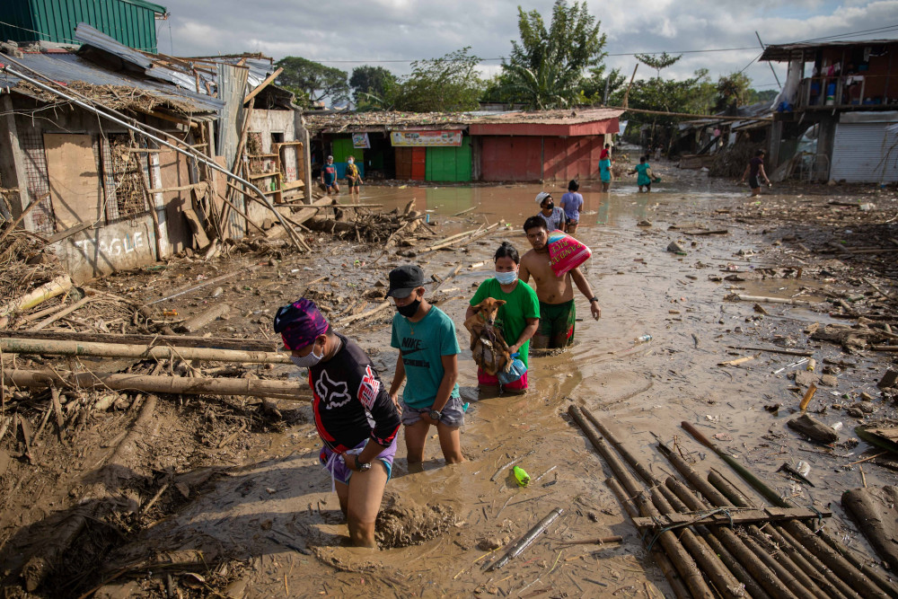 Residents walk through mud in Manila, Philippines, Nov. 14, 2020, after flooding caused by Typhoon Vamco. (CNS/Reuters/Eloisa Lopez)