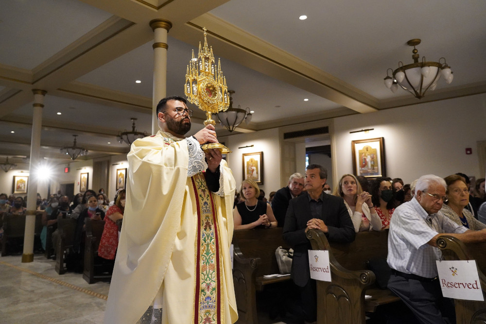 Fr. Jason Espinal, administrator of Sts. Peter & Paul-Epiphany Parish in the Brooklyn borough of New York City, processes with a reliquary containing the relics of Sts. Peter and Paul during the dedication of the church on its patronal feast June 29. (CNS