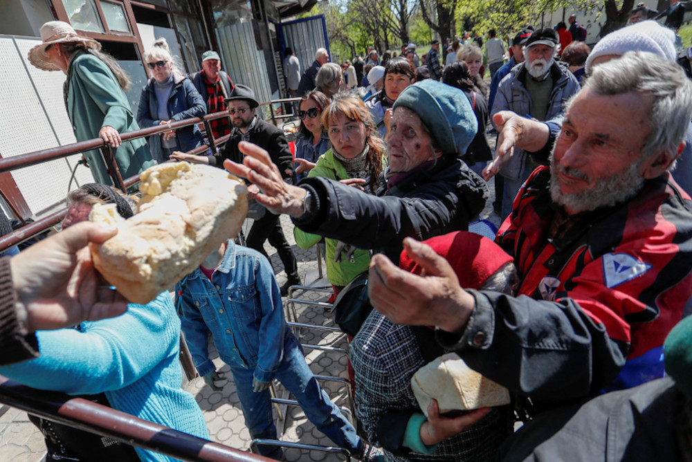 People receive bread during the May 8 distribution of humanitarian aid in the southern port city of Mariupol, Ukraine, during the Russian invasion. (CNS/Reuters/Alexander Ermochenko)