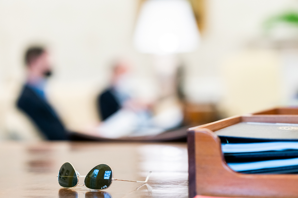 President Biden's sunglasses are seen on the Resolute Desk during an April 11 infrastructure meeting with White House staff in the Oval Office of the White House. (Official White House photo/Cameron Smith)