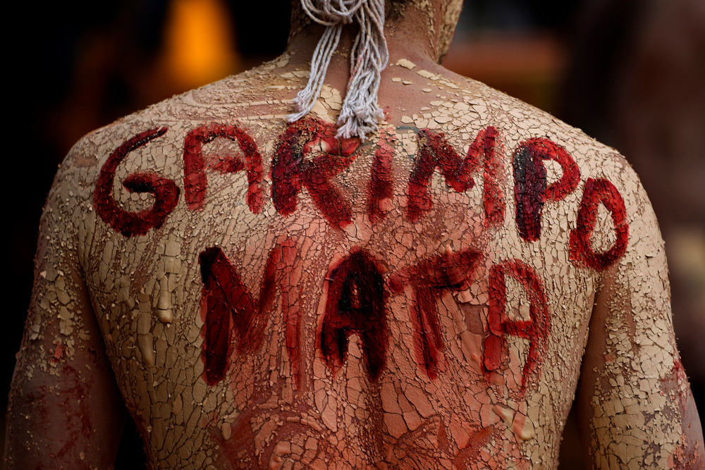 An Indigenous man with a phrase in Portuguese painted on his back that translates to "Mining Kills," participates in a protest against the increase of mining activities that are encroaching on his land. (AP/File/Eraldo Peres)