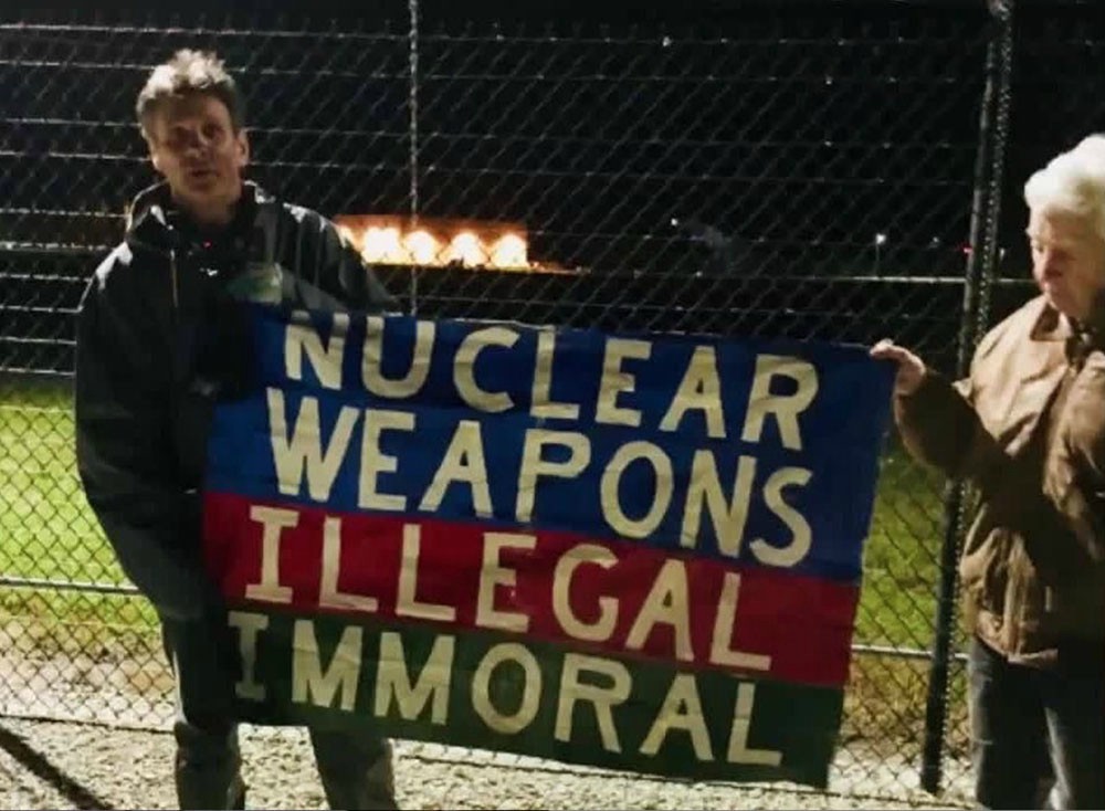 Carmen Trotta, left, and Elizabeth McAlister hold a sign while entering the Kings Bay Naval Submarine Base in St. Marys, Georgia. (RNS/Courtesy of the Kings Bay Plowshares 7)