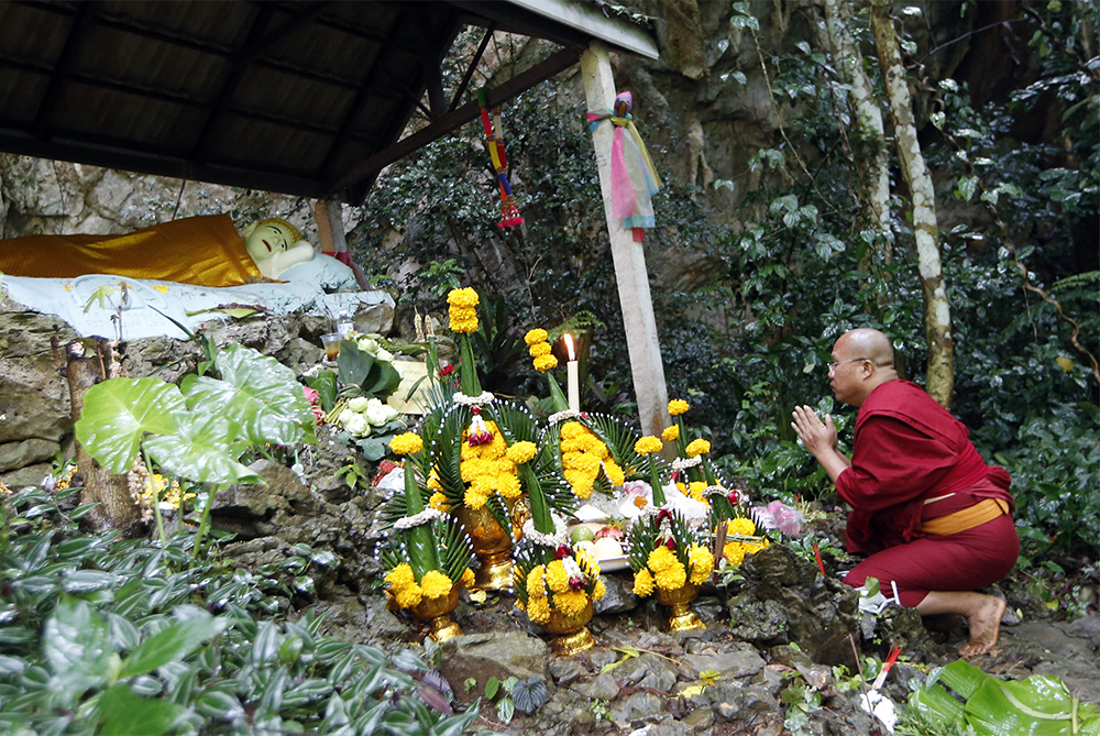 A Thai Buddhist monk prays for 12 boys and their soccer coach in Mae Sai, Chiang Rai province, in northern Thailand, on June 27, 2018. All were eventually rescued. (AP Photo/Sakchai Lalit)