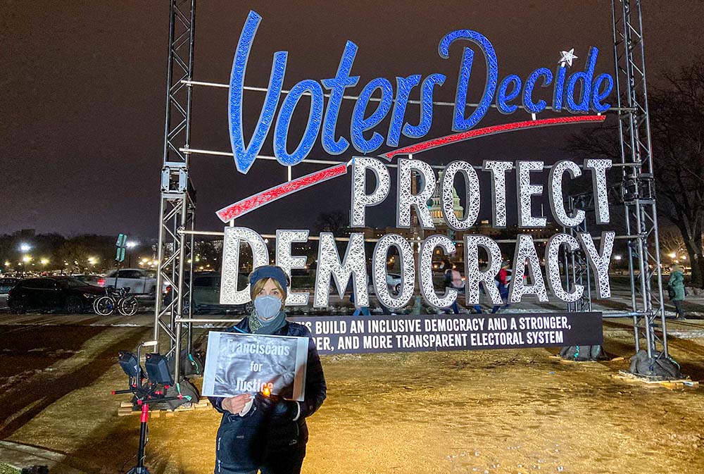 Michele Dunne poses Jan. 6, 2022, in Washington during an event in observance of the first anniversary of the attack on the U.S. Capitol in 2021. Dunne, a lay Franciscan, took part in the "Fight Fire with Light" interfaith candlelight vigil in Washington, calling on others to defend truth and democracy. (CNS/Courtesy of Franciscan Action Network)