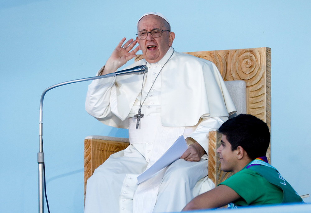 Pope Francis signals that hundreds of thousands of young people are not loud enough after he asks them to repeat that there is space for "everyone, everyone, everyone" in the church. Francis spoke at the World Youth Day welcome ceremony at Eduardo VII Park in Lisbon, Portugal, on Aug. 3, 2023. (CNS/Lola Gomez)