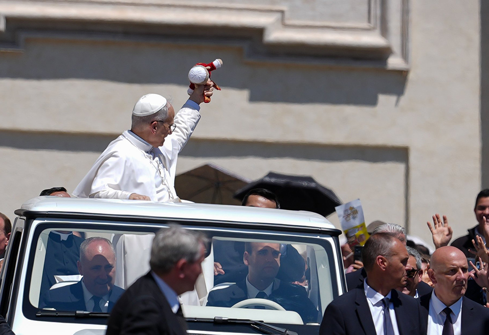 Pope Leo XIV catches a cloth doll thrown by a visitor as he rides in the popemobile following his second weekly general audience in St. Peter’s Square at the Vatican, May 28, 2025. (CNS/Lola Gomez)