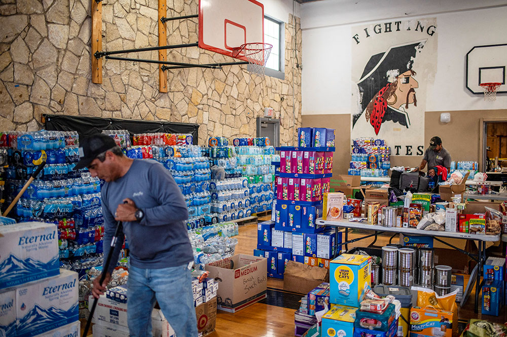 Alejandro Campos sweeps the floor at a makeshift donation center at Center Point High School in Texas July 7, 2025, in the aftermath of deadly flooding. (OSV News/Reuters/Sergio Flores)