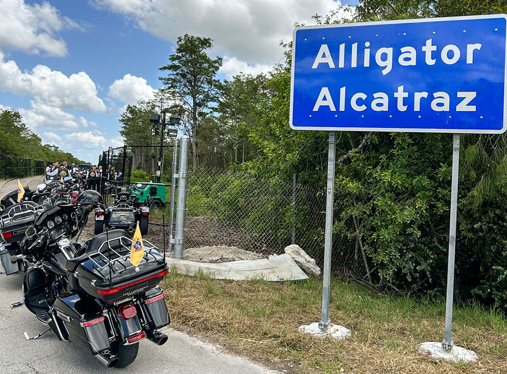 Motorcycles ridden by Miami Archbishop Thomas Wenski and Knights on Bikes are parked in front of the entrance to Alligator Alcatraz, a controversial immigration detention facility some 55 miles from Miami in the Florida Everglades. The archbishop and his fellow bikers stopped to pray a rosary for detainees July 20, 2025. (OSV News/Thomas G. Wenski)