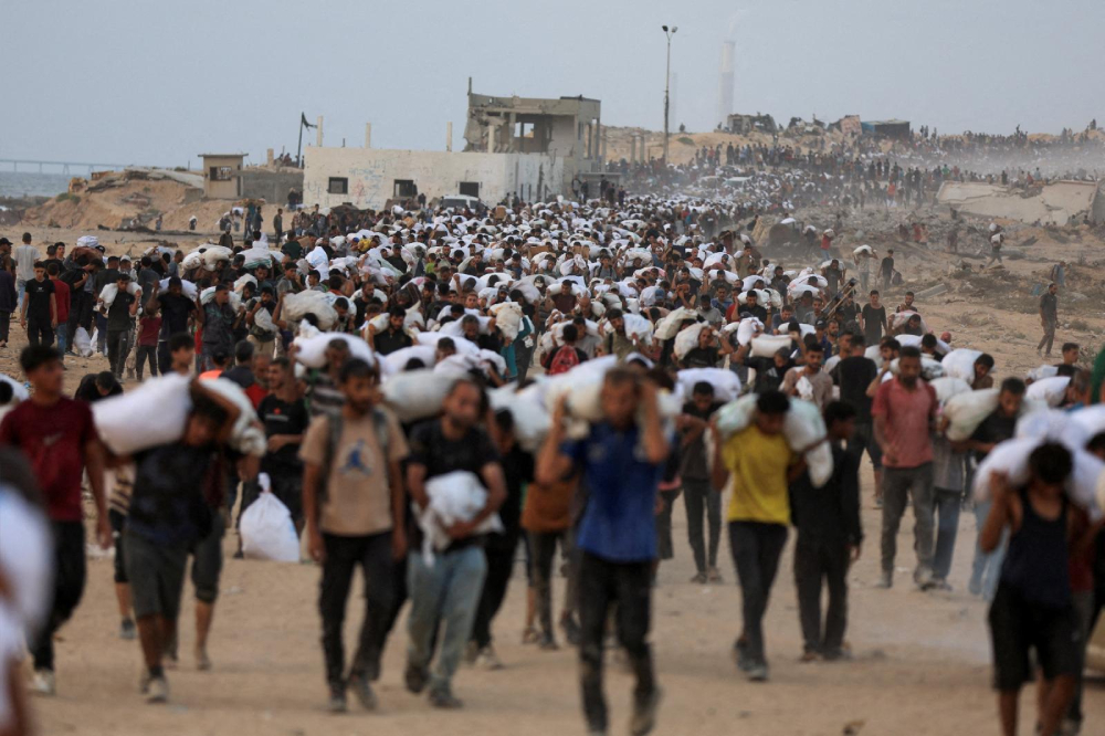 Palestinians carry aid supplies, that entered Gaza on trucks through Israel, in Beit Lahia, in the northern Gaza Strip July 29, 2025. Despite daunting odds, Catholic Relief Services and its on-the-ground partners have managed to deliver aid to 1.7 million people in Gaza since 2023, according to new data. (OSV News/Dawoud Abu Alkas/Reuters)