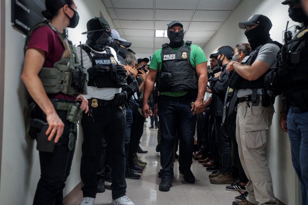 Masked federal agents wait outside an immigration courtroom on July 8 in New York.