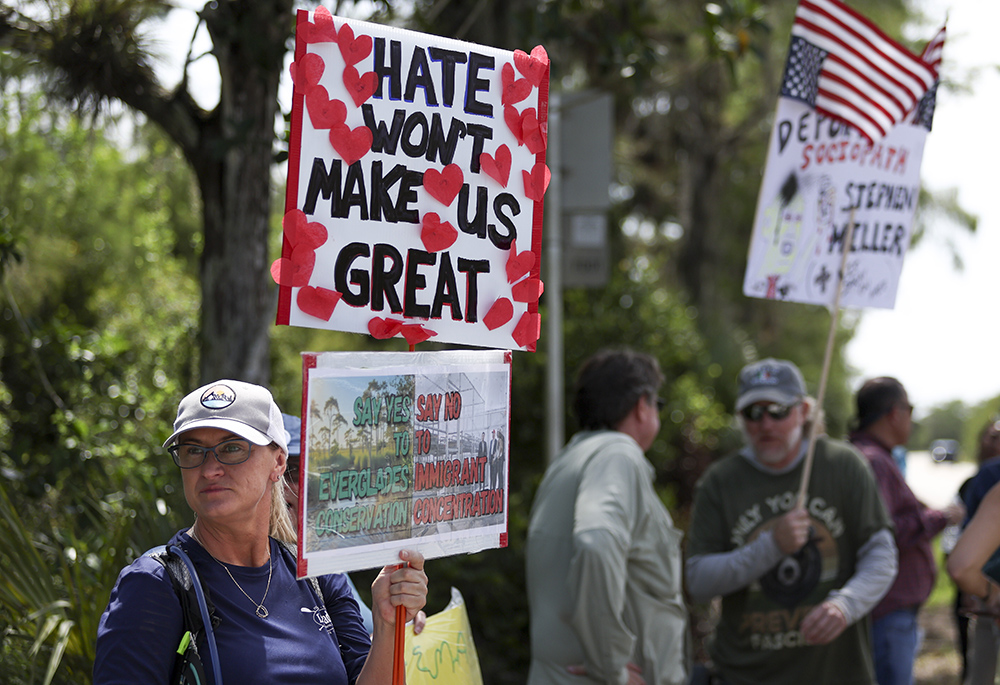 A protester stands outside the migrant detention facility dubbed "Alligator Alcatraz" at the Dade-Collier Training and Transition Facility, July 12, 2025, in Ochopee, Flordia. (AP photo/Alexandra Rodriguez)