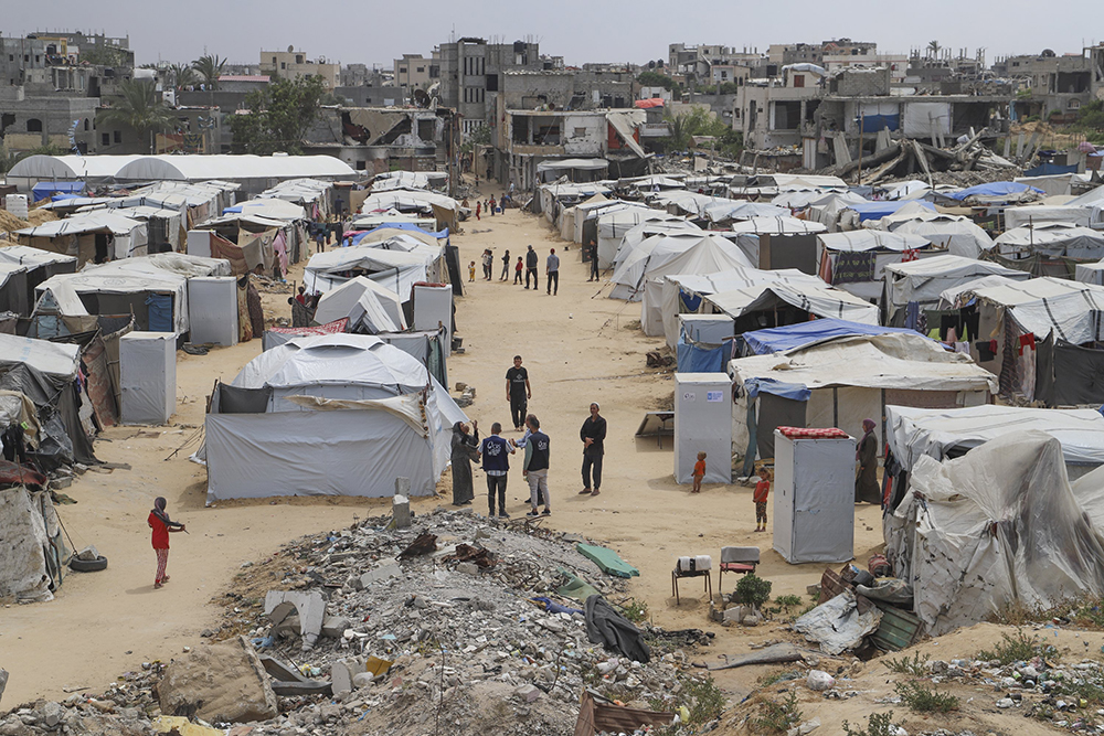 Catholic Relief Services workers talk with people at a tent camp for displaced Palestinians in Gaza May 5, 2025. (OSV News/CRS Staff)