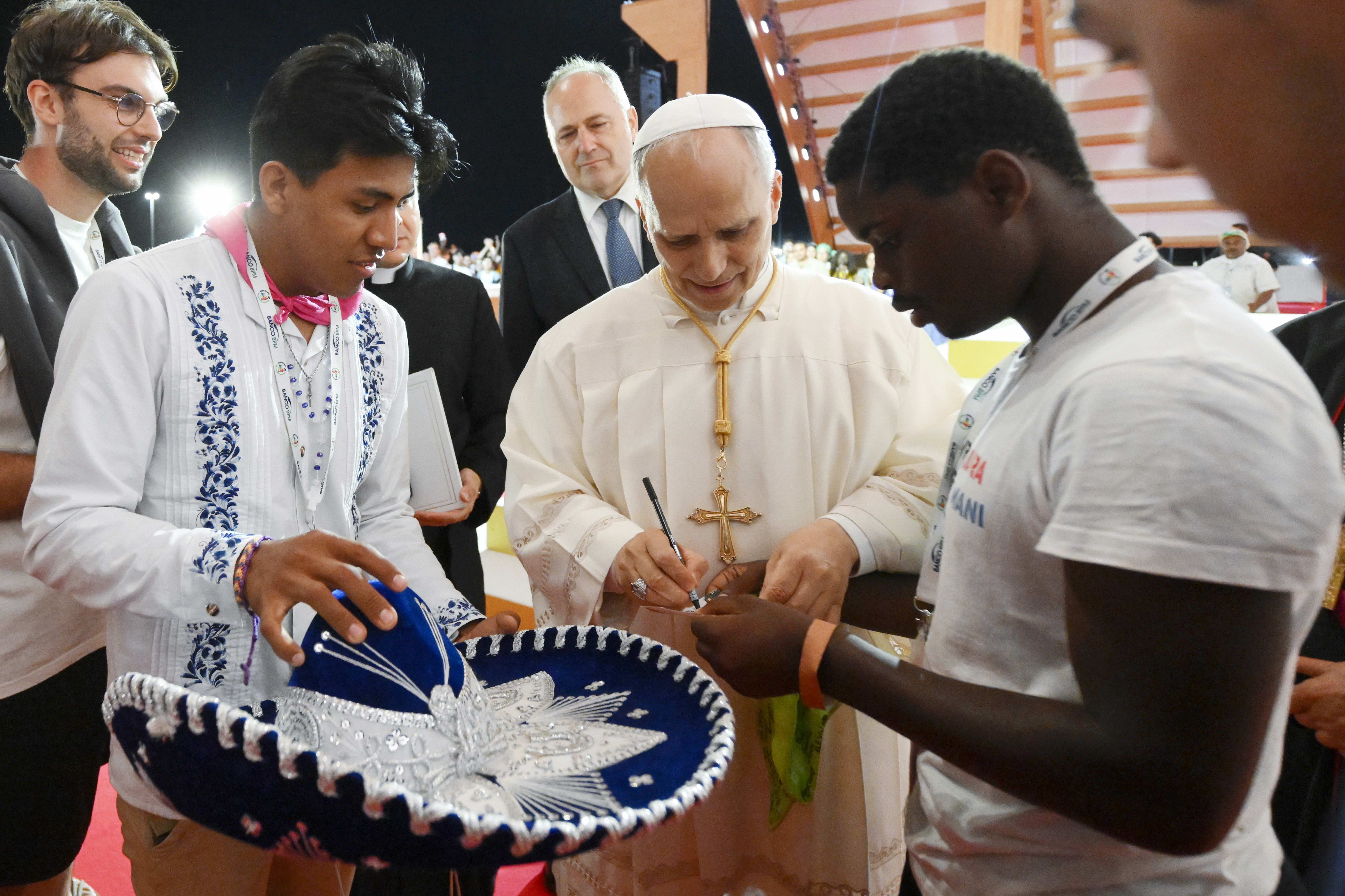 Pope Leo XIV signs his name for a young man after presiding over a prayer vigil with hundreds of thousands of young people in Rome's Tor Vergata neighborhood Aug. 2, 2025. (CNS/Vatican Media)