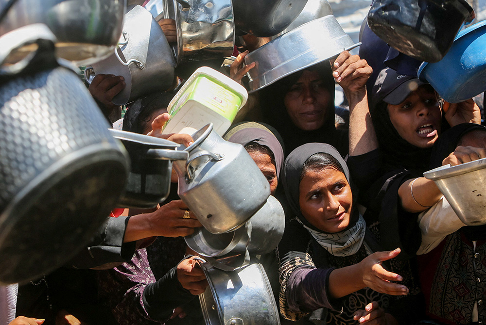 Displaced people wait to receive food Aug. 2, 2025, from a charity kitchen in Gaza City, Gaza Strip, amid a hunger crisis. (OSV News/Reuters/Hatem Khaled)