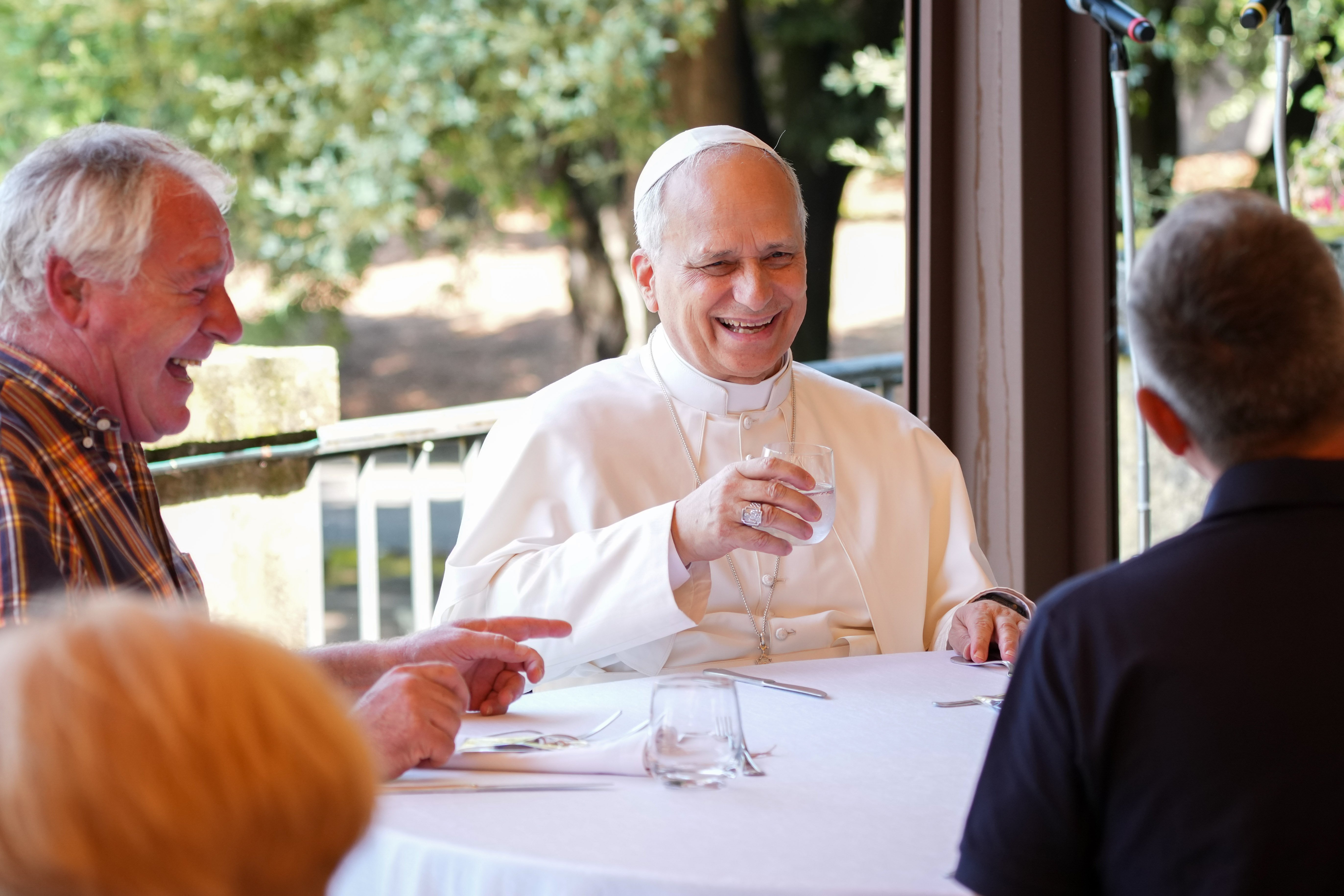 Pope Leo XIV shares a laugh with guests assisted by the Albano diocesan Caritas agency during a luncheon at the Borgo Laudato Si’ in Castel Gandolfo, Italy, Aug. 17, 2025. (CNS photo/Lola Gomez)