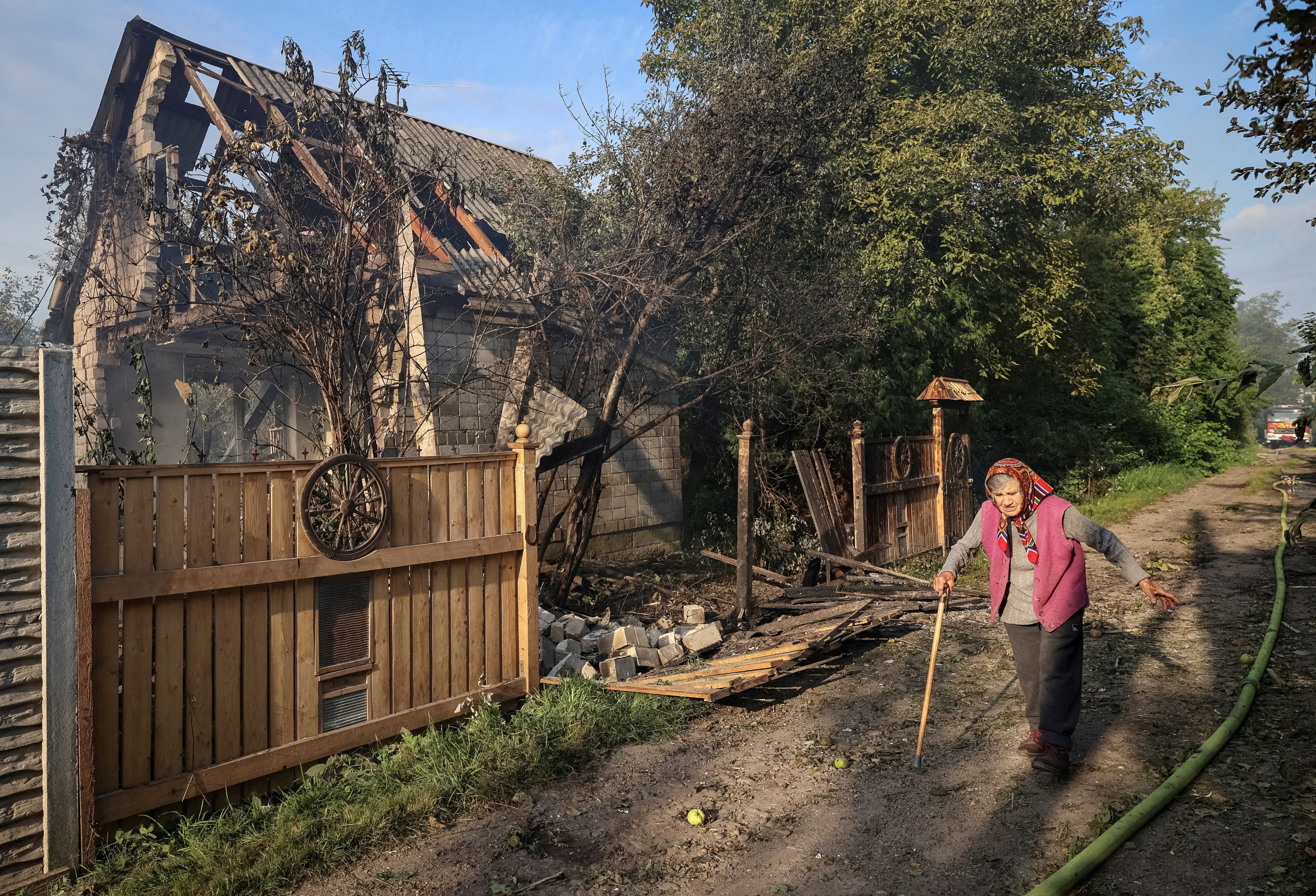  A woman walks past a destroyed home at the site of a Russian airstrike in the Ukrainian village of Sknyliv on the outskirts of Lviv, Aug. 21, 2025. (OSV News photo/Roman Baluk, Reuters)