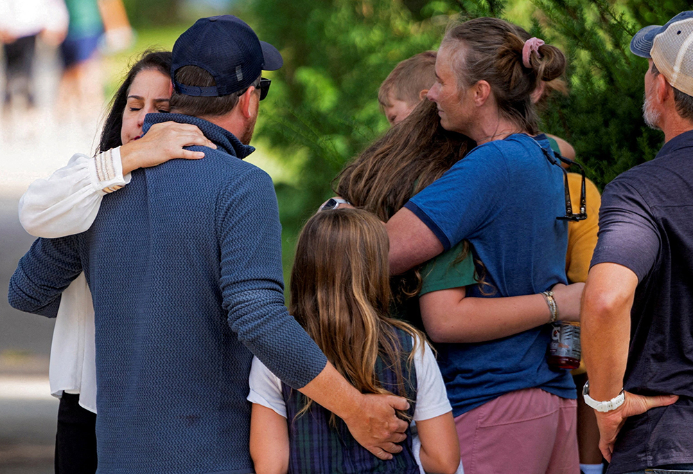 Families and loved ones reunite following a shooting at Annunciation Catholic School in Minneapolis Aug. 27, 2025. A shooter opened fire with a rifle through the windows of the school's church and struck children celebrating Mass during the first week of school, killing two and wounding 17 people in an act of violence the police chief called "absolutely incomprehensible." (OSV News/Reuters/Ben Brewer)