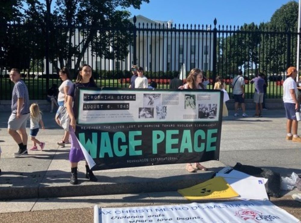 People hold sign that says, "Wage Peace." 