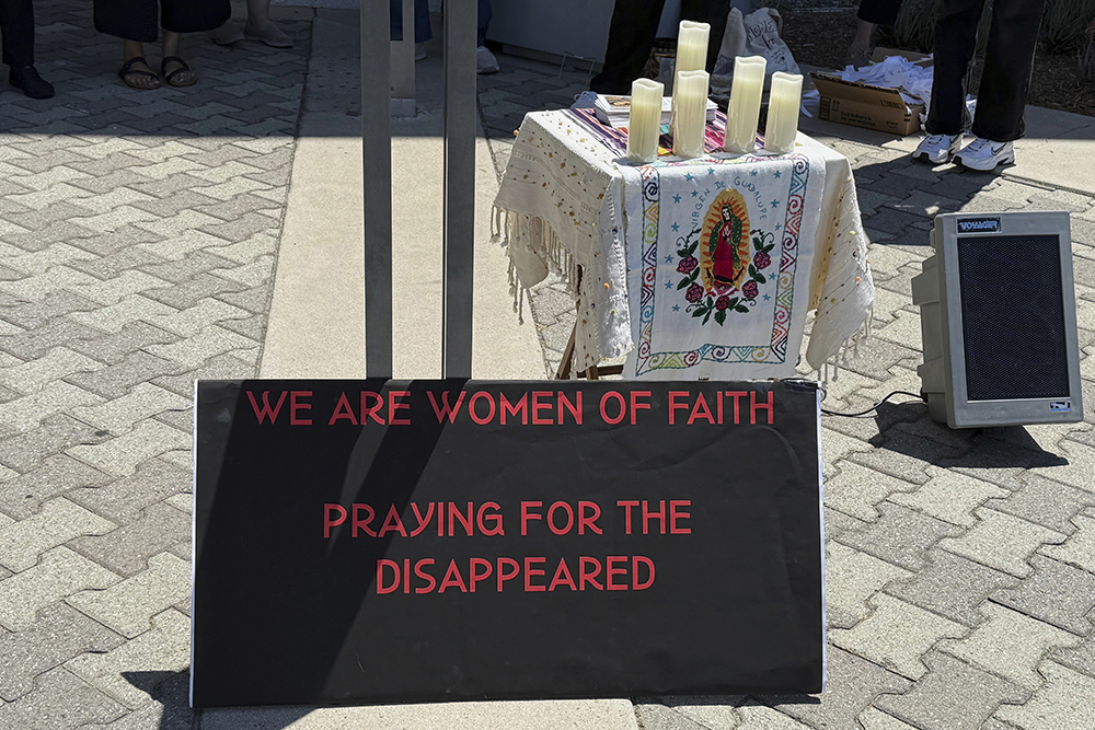 A sign and a shrine bearing the image of Our Lady of Guadalupe are placed outside Santa Ana Immigration Court during a prayer vigil for immigrants in Santa Ana, Calif., July 31, 2025. (AP Photo/Deepa Bharath)