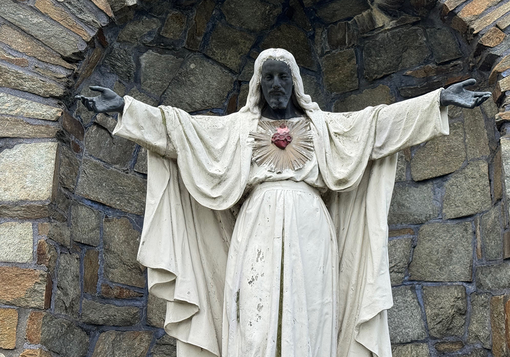 An outdoor hallmark alabaster statue of Jesus Christ is pictured at Detroit's Sacred Heart Major Seminary in August 2025. During rioting in 1967, the statue was painted over — Jesus' face, hands and feet were covered in black paint. Then-rector Msgr. Francis X. Canfield decided to keep it that way as a sign of solidarity with the Black community. (Patricia Montemurri)