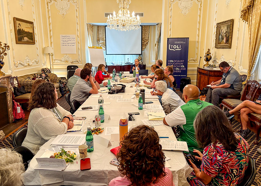 Catholic teachers sit around a table listening to Abraham Foxman's story as a Holocaust survivor hidden by a Catholic community, as part of a seminar organized by the Olga Lengyel Institute for Holocaust Studies and Human Rights in New York, July 25, 2025. (NCR photo/Camillo Barone)