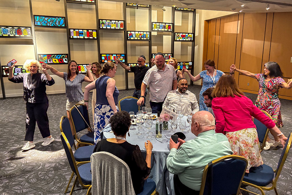 Catholic teachers do a traditional Jewish dance during a Shabbat dinner organized by the Olga Lengyel Institute for Holocaust Studies and Human Rights at Park Avenue Synagogue in Manhattan's Upper East Side, July 25, 2025. (NCR photo/Camillo Barone)