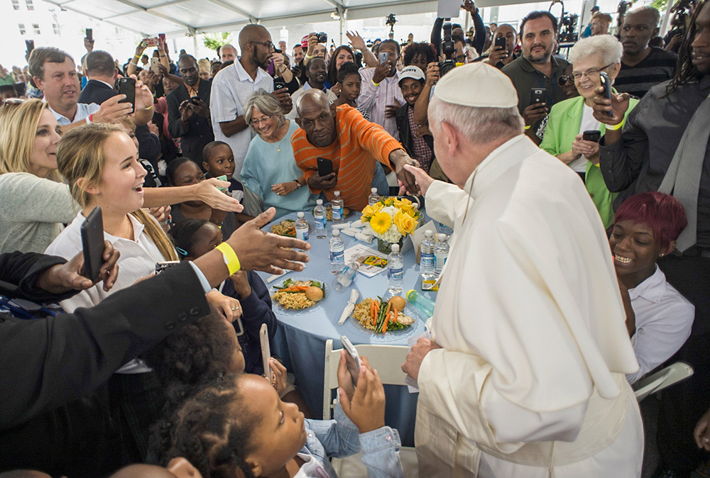 On Sept. 24, 2015, Pope Francis is greeted as he arrives at a lunch for homeless people who are regularly fed by Catholic Charities, at St. Patrick's Church in Washington, D.C. (L'Osservatore Romano/Pool Photo via AP)