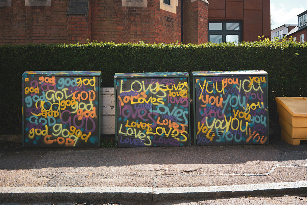 "God loves you" is painted on concrete blocks (Unsplash/John Crozier)