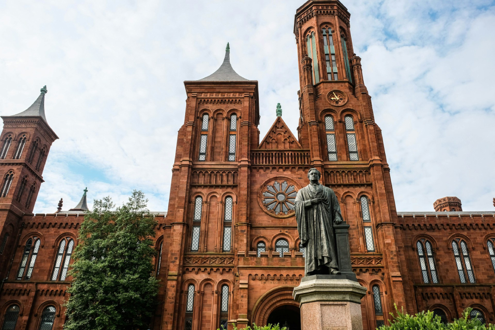 A view of the front of the Smithsonian Castle when arriving from The National Mall which includes a view of the statue of the Smithsonian's first secretary, Joseph Henry.