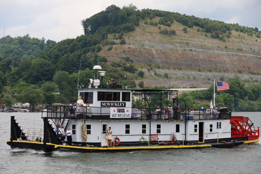From the sternwheeler in the Eucharistic procession on the Ohio River for Seton Route of the National Eucharistic Pilgrimage June 24, 2024, Bishop Mark E. Brennan of Wheeling-Charleston, W.Va., bestows a Eucharistic blessing to the faithful gathered at the Wellsburg Wharf in Wellsburg, W.Va. (OSV News/The Catholic Spirit/Colleen Rowan)