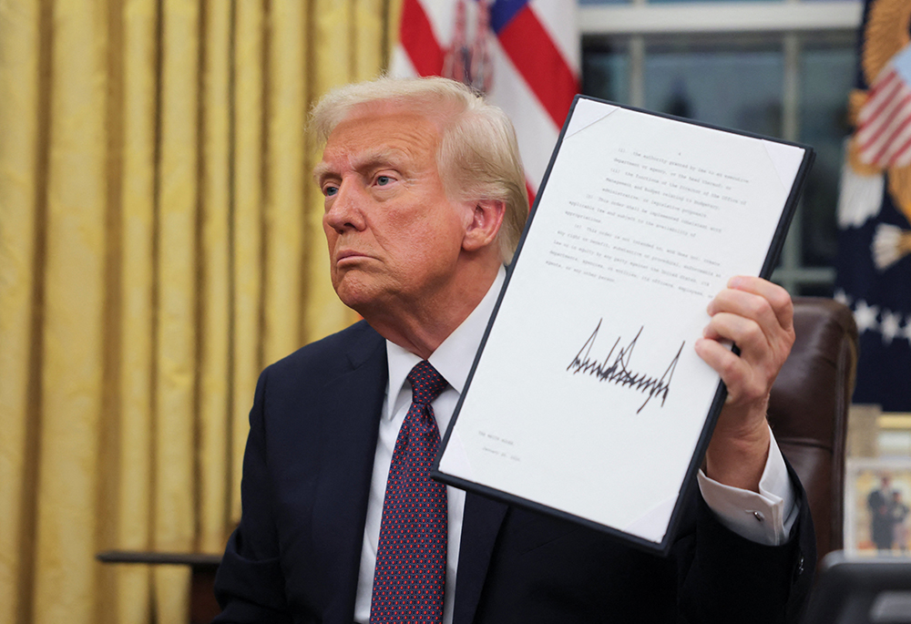 U.S. President Donald Trump signs documents in the Oval Office at the White House on Inauguration Day in Washington Jan. 20, 2025. He signed a series of executive orders, including an order granting about 1,500 pardons for those charged in connection with the Jan. 6, 2021, riot at the U.S. Capitol. (OSV News/Reuters/Carlos Barria)
