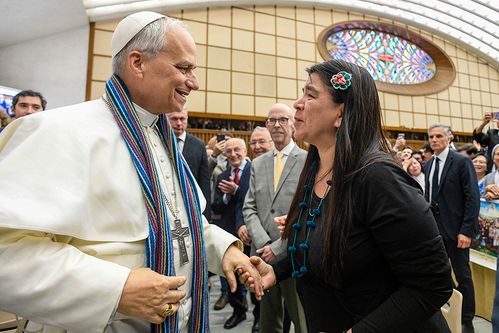 Paola Ugaz, a Peruvian journalist who helped expose the abuse committed by leaders of the Sodalitium Christianae Vitae, gives Pope Leo XIV a stole made of alpaca wool, during the new pope's meeting with members of the media May 12, 2025, in the Paul VI Audience Hall at the Vatican. (CNS/Vatican Media)