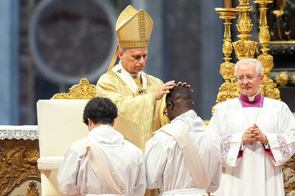 Pope Leo XIV lays hands on an ordinand during Mass on the feast of the Sacred Heart of Jesus in St. Peter’s Basilica at the Vatican June 27, 2025. The pope ordained 32 men from five continents. (CNS/Lola Gomez)