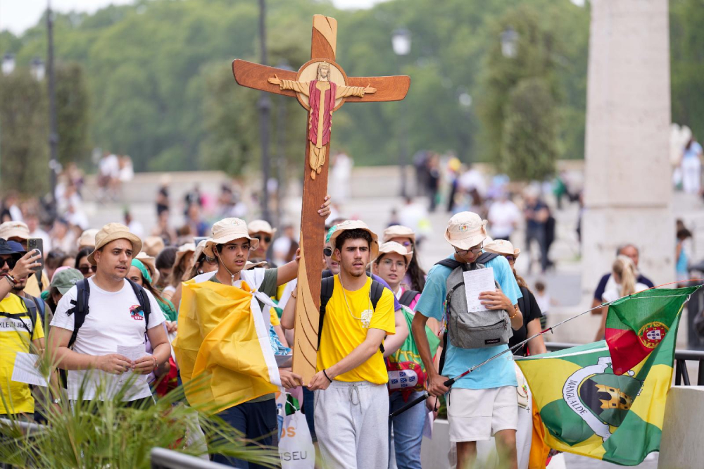 Young pilgrims carry a cross as they walk toward the Vatican during a pilgrimage in Rome, July 28, 2025. (CNS/Lola Gomez)