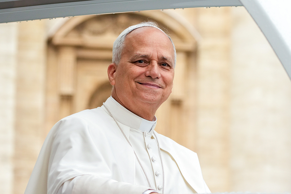 Pope Leo XIV smiles as he greets visitors and pilgrims from the popemobile under the rain in St. Peter’s Square at the Vatican before his weekly general audience Sept. 10, 2025. (CNS/Lola Gomez)