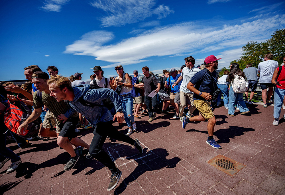 People run after a shot was fired at U.S. conservative activist Charlie Kirk during a Utah Valley University speaking event in Orem, Utah, Sept. 10, 2025. (OSV News/Trent Nelson, The Salt Lake Tribune via Reuters)