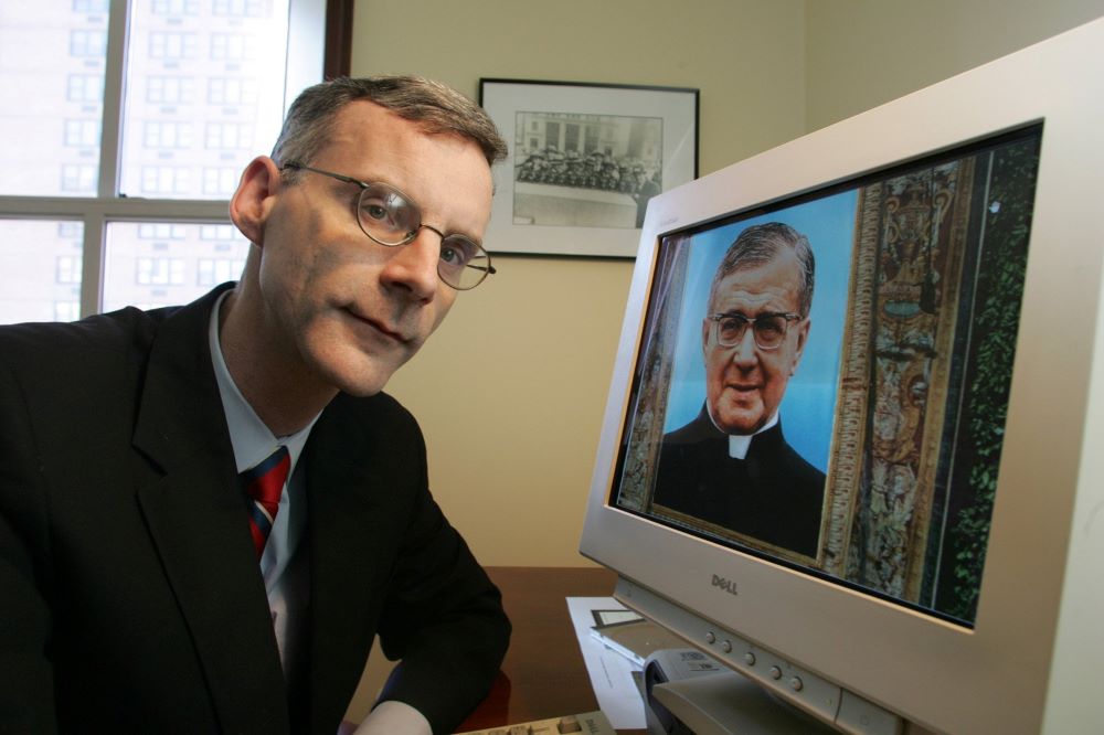 Brian Finnerty, U.S. spokesman for Opus Dei, poses inside the international Catholic organization's New York headquarters with a digital photograph of St. Josemaría Escrivá de Balaguer in 2006. (CNS/Todd Plitt)