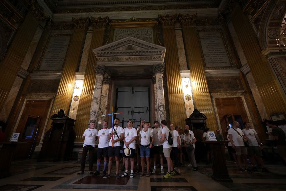 Andrea Mattei, holding a cross, arrives with other members of the LGBTQ+ community to attend a vigil prayer in the Church of the Gesu' in central Rome, Friday, Sept. 5, 2025. (AP Photo/Andrew Medichini)