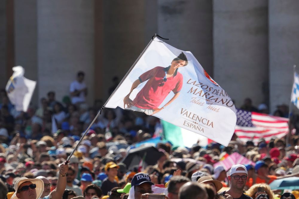 A flag featuring the image of Carlo Acutis is waved during the canonization Mass of Carlo Acutis and Pier Giorgio Frassati in St. Peter's Square at the Vatican on Sept. 7. (AP/Andrew Medichini)