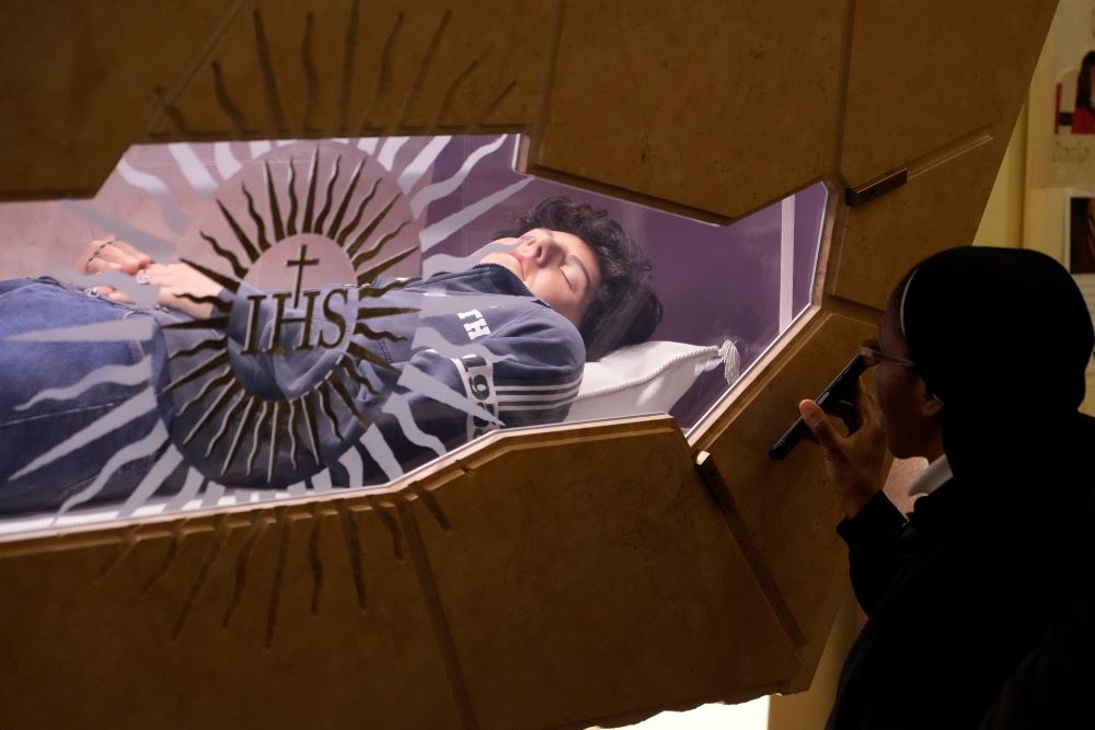 The body of Carlo Acutis, an Italian boy who died in 2006 of leukemia, lies in his tomb in Assisi, Italy, March 1. (AP/Gregorio Borgia, File)