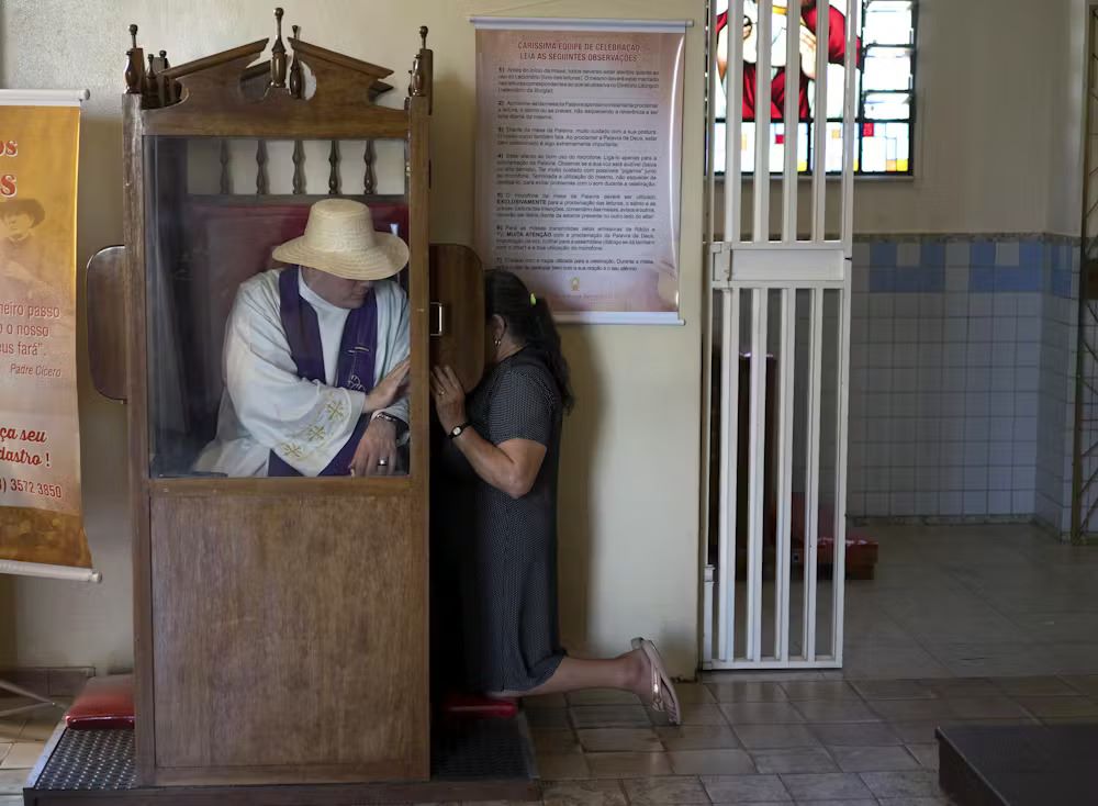 A priest listens to a pilgrim’s confession at Our Lady of Perpetual Help Church in Juazeiro do Norte, Brazil, on Oct. 30, 2015. (The Conversation/AP/Leo Correa)