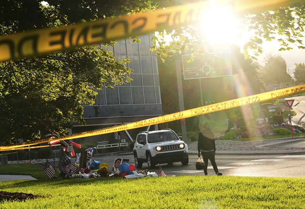 A person walks by a growing memorial at Utah Valley University after Turning Point USA CEO and co-founder Charlie Kirk was shot and killed Sept. 13, 2025, in Orem, Utah. (AP photo/Lindsey Wasson)
