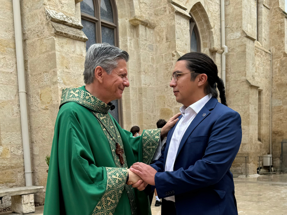 Antonio Frietze, right, who helped lead an effort for the Archdiocese of San Antonio to join the Laudato Si Platform, shakes hands with Archbishop Gustavo Garcia-Siller, left, during a mass celebrating making a climate action commitment. (Courtesy of Catholic Climate Covenant)