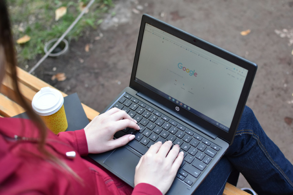 Someone using Google on a laptop outside