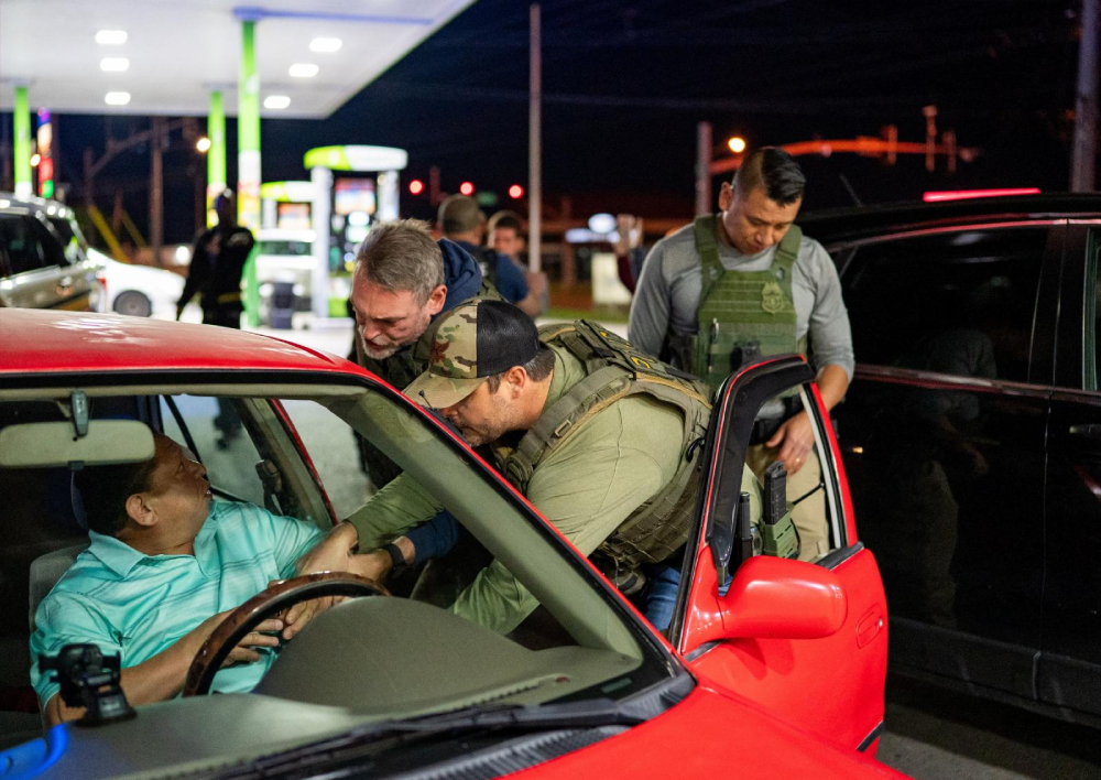 U.S. Immigration and Customs Enforcement officers detain a man from a car stopped by Tennessee Highway Patrol at a gas station in South Nashville, as he could not produce any alternative identification proof other than his expired driving license, during an operation conducted by ICE along with THP to detain noncitizens across the city of Nashville, Tenn., May 10, 2025. (OSV News/Reuters/Seth Herald)
