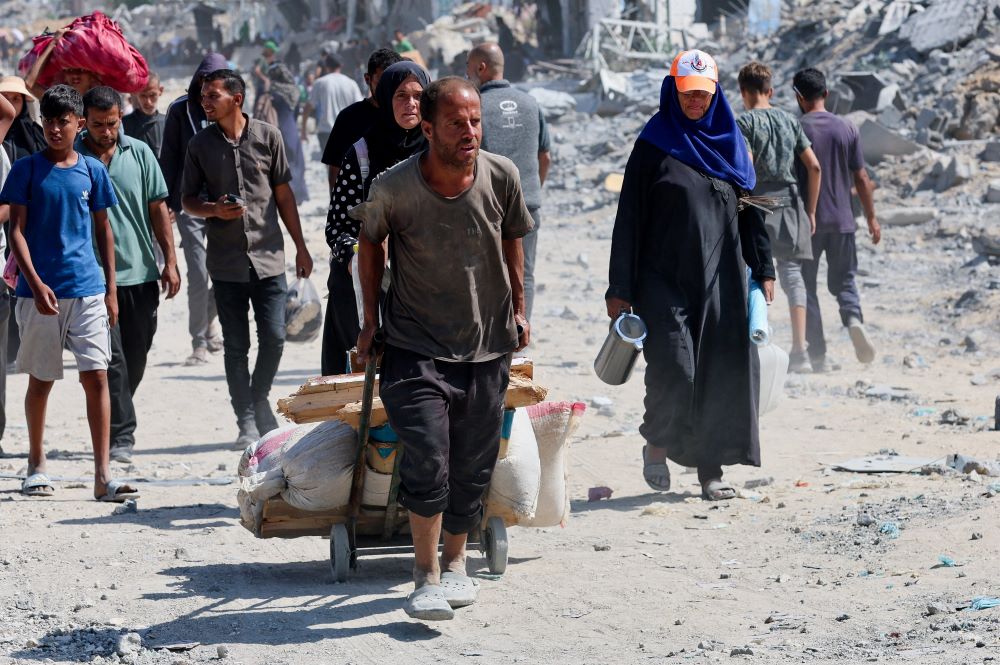 Displaced Palestinians walk past the rubble in Khan Younis, in the southern Gaza Strip, following Israeli forces' withdrawal from the area Oct. 10. 